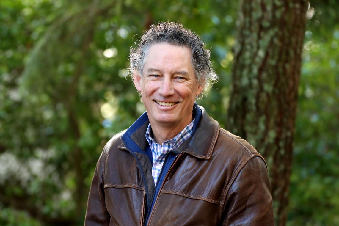  image of a smiling Leif Rasmussen in front of greenery 